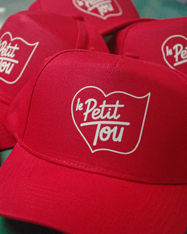 Casquettes rouges en série, DTF, Le Petit Tou, atelier Antistatik à Toulouse